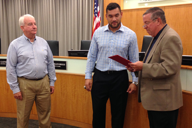 Bloomington alderman Jim Fruin reads a proclamation delcaring Aug. 6 to be "Michael Hoomanawanui Day" in Bloomington-Normal with Hoomanawanui and Normal councilman Jeff Fritzen. (Joe Ragusa/WJBC)