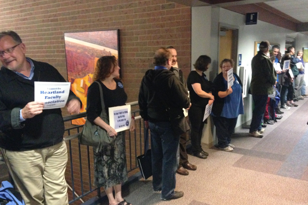 Several members of the Heartland Faculty Association line the halls outside of the Heartland Community College board of trustees meeting Tuesday. (Joe Ragusa/WJBC)